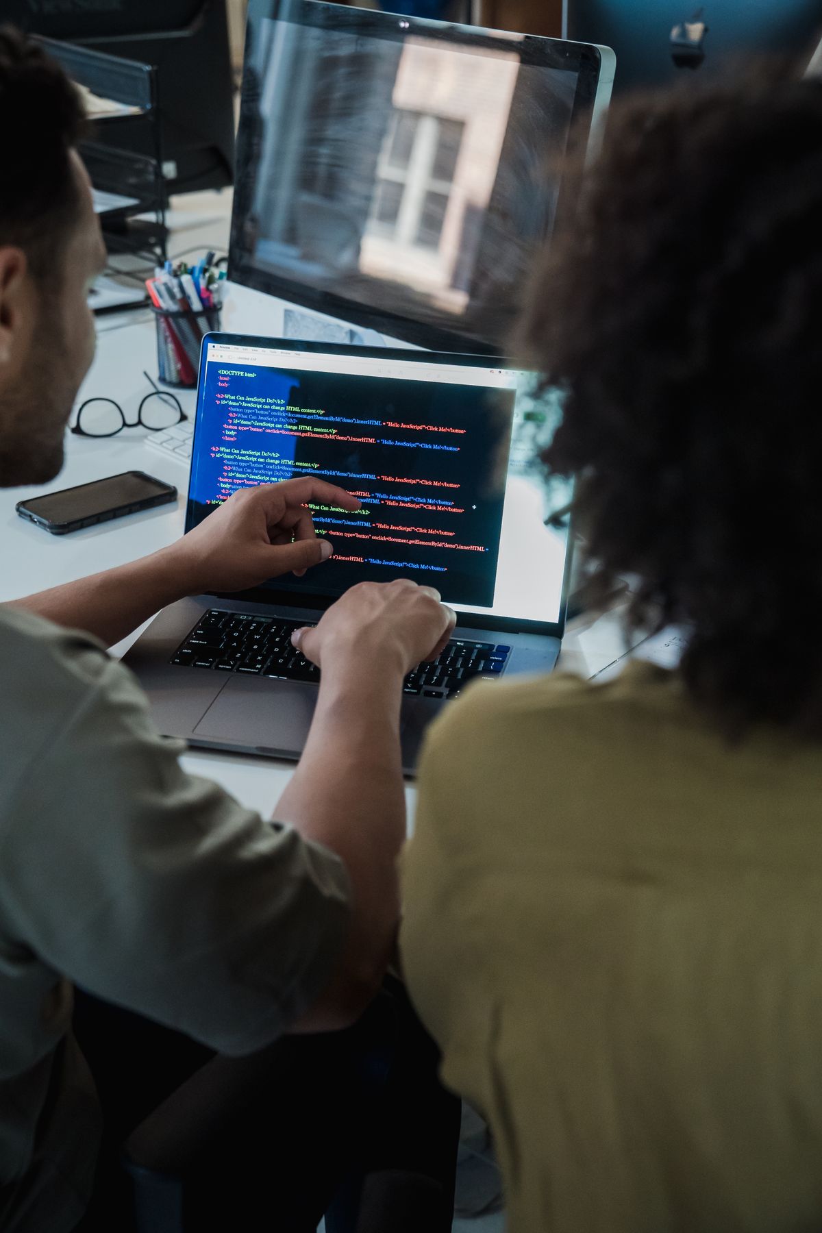 Two software engineers reviewing code on a laptop